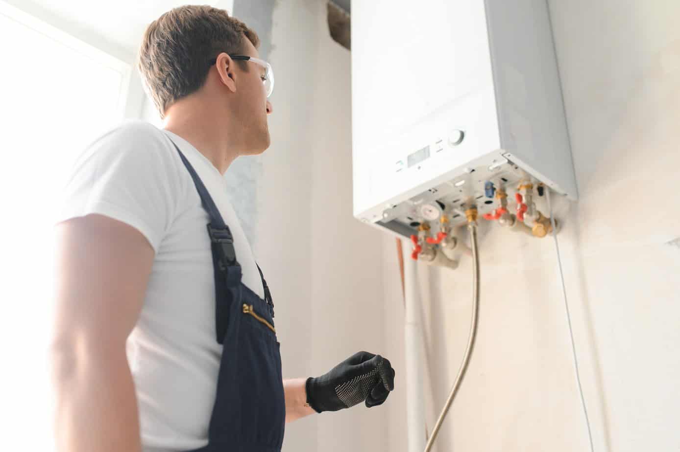 Professional plumber checking a boiler and pipes, boiler service concept